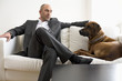 Businessman sitting on sofa with dog