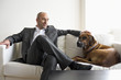 Businessman sitting on sofa with dog