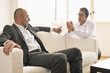 Mid adult man persuading mature man