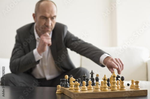 Photo: Businessman playing chess Businessman playing chess