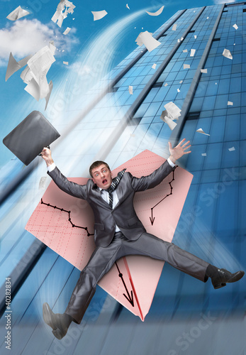 Foto: Businessman falling on paper airplane Businessman falling on paper airplane