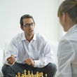 Mid adult couple playing chess, side view