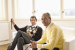 Men holding golf clubs, smiling, portrait