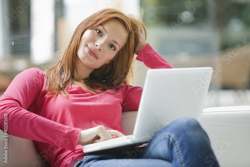 Photo: Young woman using laptop, portrait Young woman using laptop, portrait