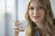 Young woman holding coffee cup, portrait
