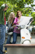 Young women sitting on motor scooter, smiling