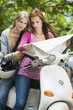 Young women looking at map, smiling