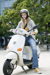 Young woman sitting on motor scooter