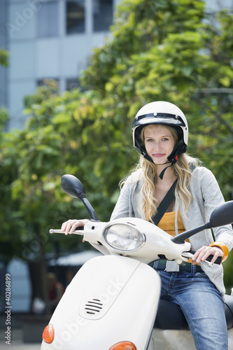 Photo: Young woman sitting on motor scooter Young woman sitting on motor scooter