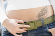 Young woman with tattoo, midsection, close-up