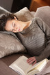 woman lying on couch with book