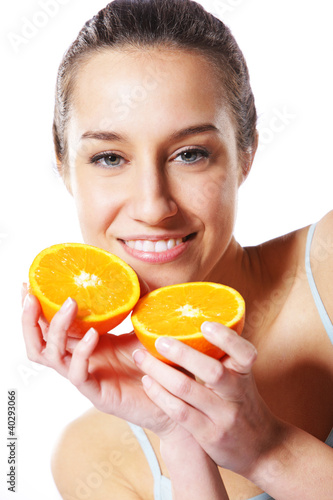 Photo: Beauty shot of a young woman with orange half Beauty shot of a young woman with orange half