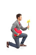 A young man holding a heart shaped pillow and bunch of flowers A young man holding a heart shaped pillow and bunch of flowers