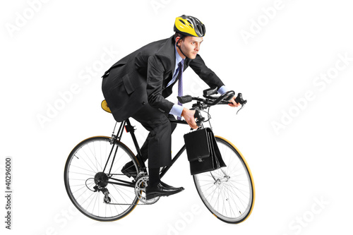 Photo: A young businessman riding a bicycle going towards his workplace A young businessman riding a bicycle going towards his workplace
