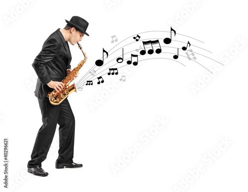 Photo: Full length portrait of a man playing on saxophone and notes com Full length portrait of a man playing on saxophone and notes com