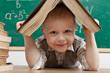 Cheerful smiling  little boy sitting at the table.