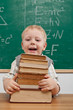 Cheerful smiling  little boy sitting at the table.