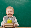 Foto: Cheerful smiling child with a book. School concept Cheerful smiling child with a book. School concept