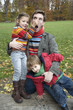 Father holding son and daughter, smiling