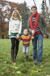 Father with mother holding daughter's hand, smiling, portrait