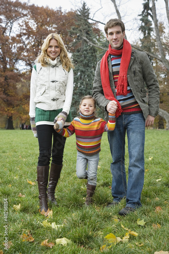 Photo: Father with mother holding daughter's hand, smiling, portrait Father with mother holding daughter's hand, smiling, portrait