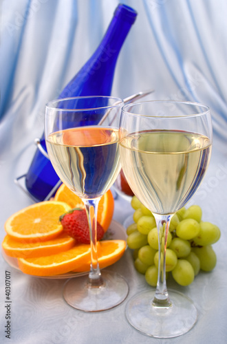 Photo: Two glasses of wine with oranges and grapes Two glasses of wine with oranges and grapes