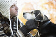 Young man looking at dog, side view, close-up