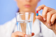 Red and blue bolus (capsule) in doctor hand, closeup view