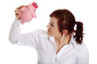 Young businesswoman trying to get money from her piggy bank