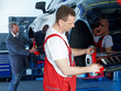 Master mechanic inspecting a break of a car on a service lift