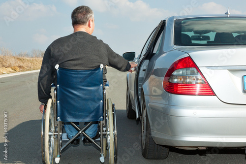 Foto: Man in a wheelchair next to his car Man in a wheelchair next to his car
