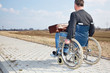 Photo: Man with suitcase wheelchair and walk on the road Man with suitcase wheelchair and walk on the road
