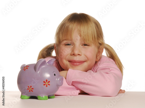 Photo: Pequeña niña sosteniendo un cerdito de ahorros. Pequeña niña sosteniendo un cerdito de ahorros.