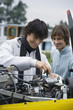 Young man screwing in airplane engine, smiling