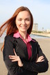 Redhead woman standing with hands folded , at the beach