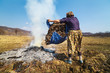 Senior rural woman burning fallen leaves
