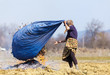 Senior rural woman burning fallen leaves