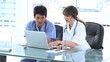Smiling medical team working with a laptop