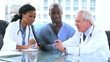 Serious doctors and an intern looking at an x-ray