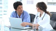 Doctor pointing at the screen of a laptop with a colleague