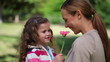 Video: Mother smelling a flower holding by her daughter Mother smelling a flower holding by her daughter