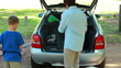 Father and son placing things in the trunk of the car