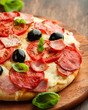 Pizza with salami, ham and tomatoes