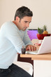 Man at home connected on internet with laptop Man at home connected on internet with laptop