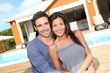 Young couple sitting in front of brand new home