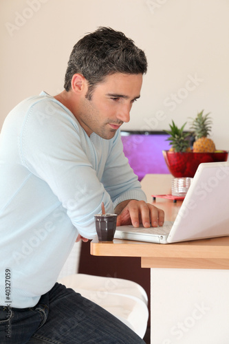 Foto: Man at home connected on internet with laptop Man at home connected on internet with laptop