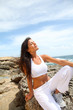 Woman sitting on rocks in fitness outfit