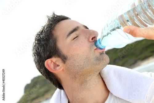 Photo: Jogger drinking water after exercising Jogger drinking water after exercising