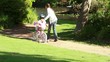 Smiling woman helping her daughter to ride a bike