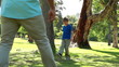 Smiling man playing with a soccer ball with his son